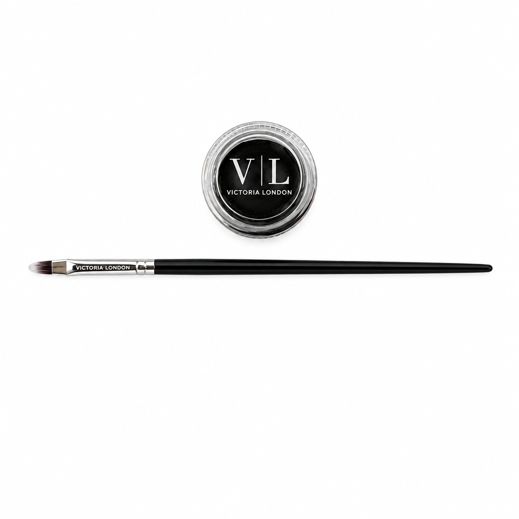 A fine detail brush with a black handle and silver ferrule, shown horizontally next to its round black and silver container lid, both featuring the Victoria London brand logo, on a plain white background.